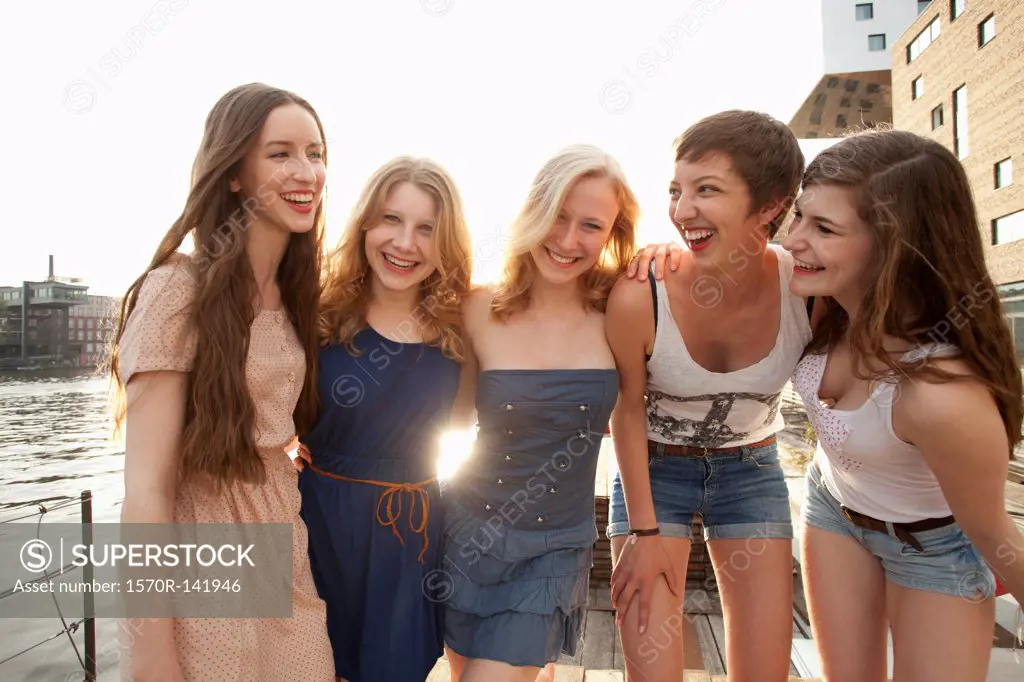 Five young women standing on a jetty next to the Spree River, Berlin, Germany