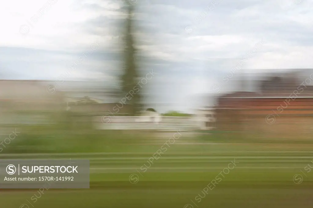 A village in blurred motion viewed from a moving train