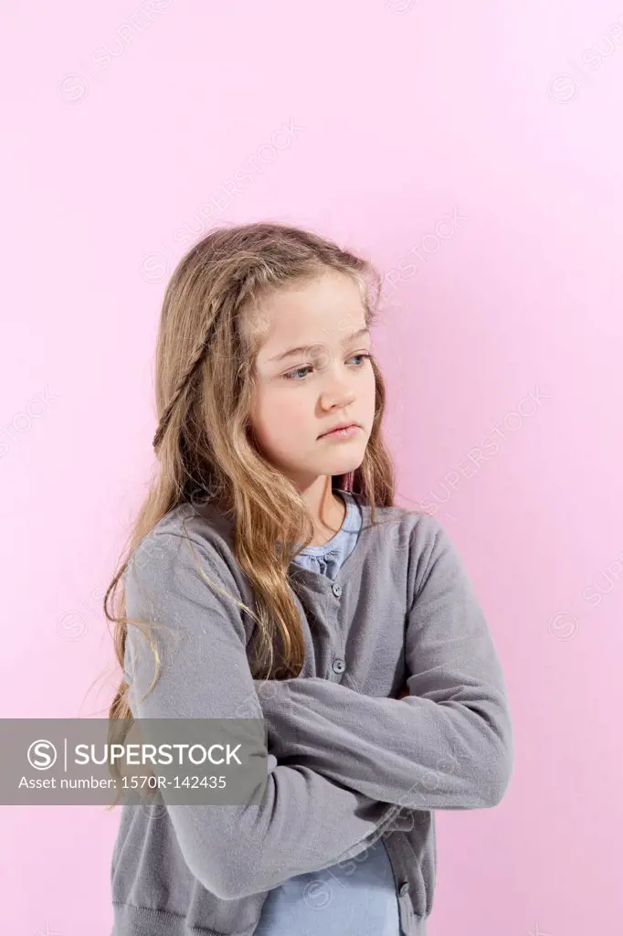 A girl with her arms crossed, looking away angrily