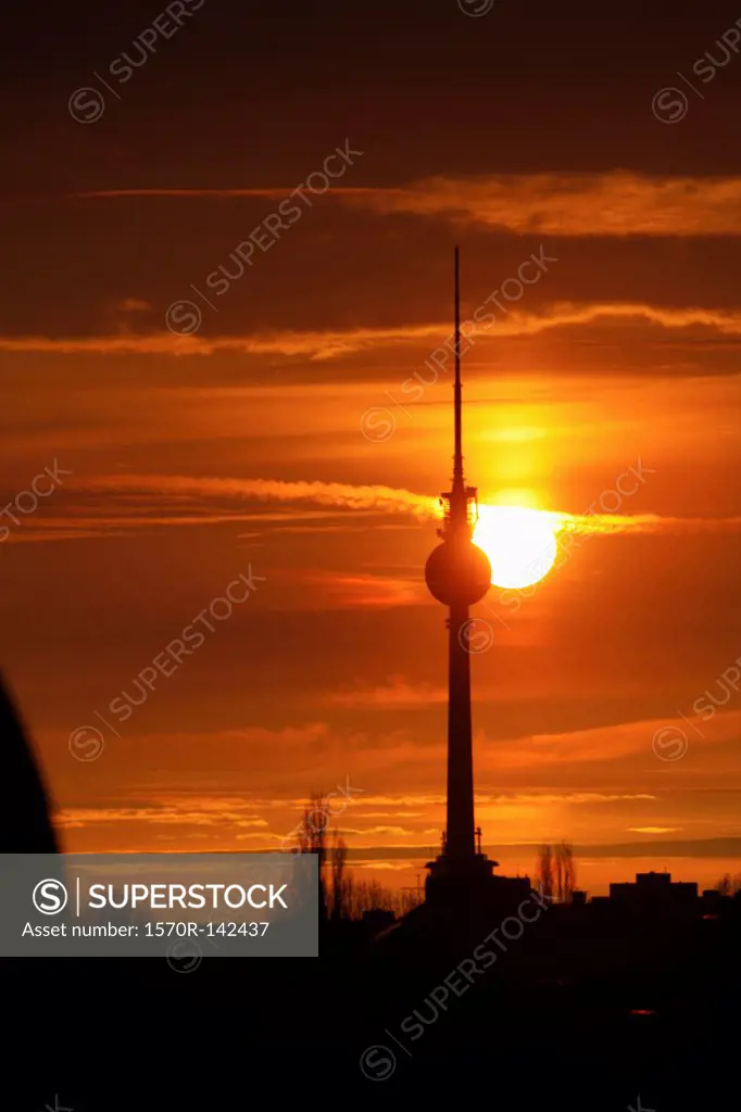The Alexanderplatz television tower silhouetted against a beautiful sky with the sun setting