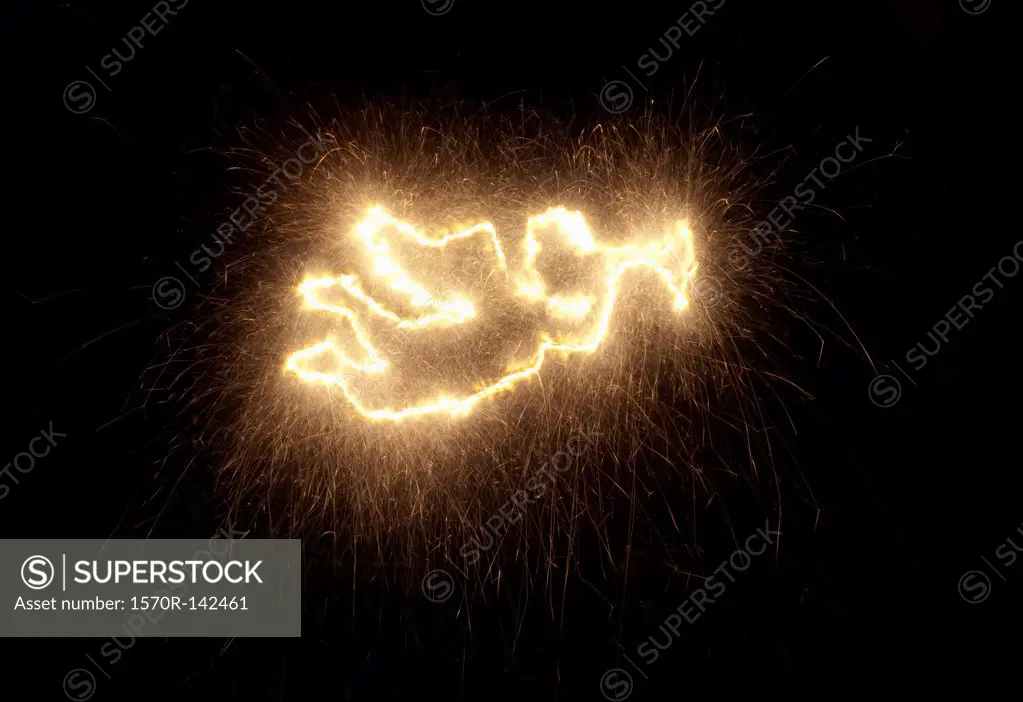 A Christmas angel blowing a trumpet, drawn on black background with sparkler