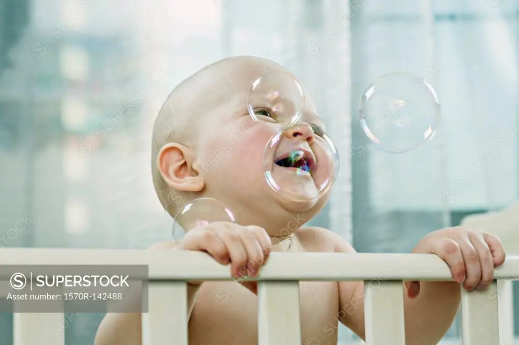 Baby in cot enjoying the bubbles
