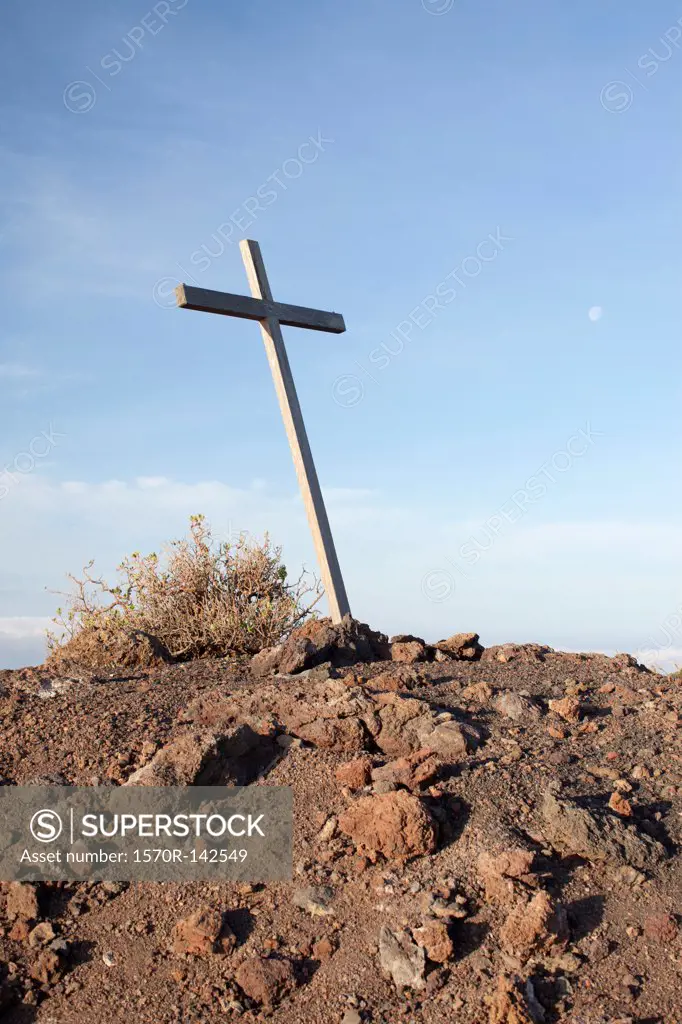 A simple wood cross on a rocky hilltop