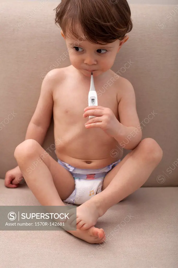A boy holding a thermometer in his mouth