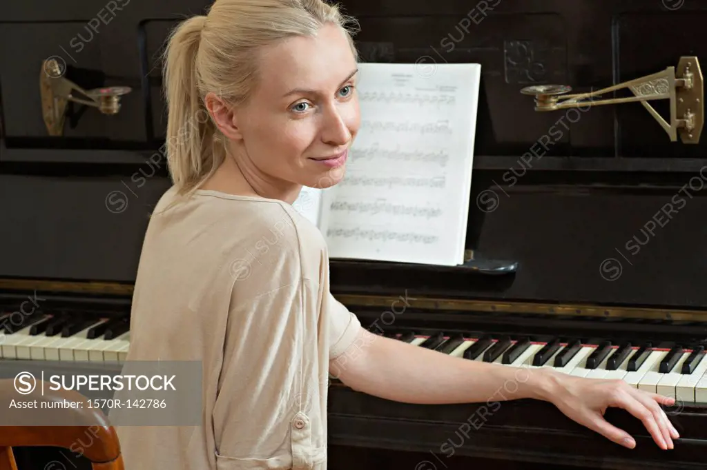 A beautiful woman sitting at a piano