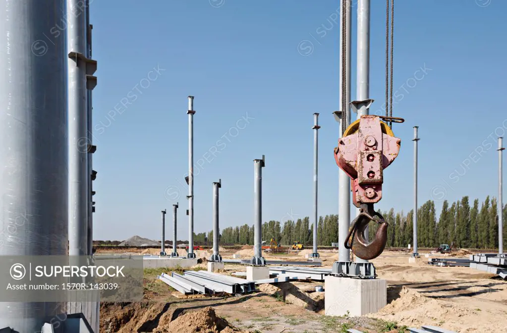 Crane hook among steel beams of construction frame