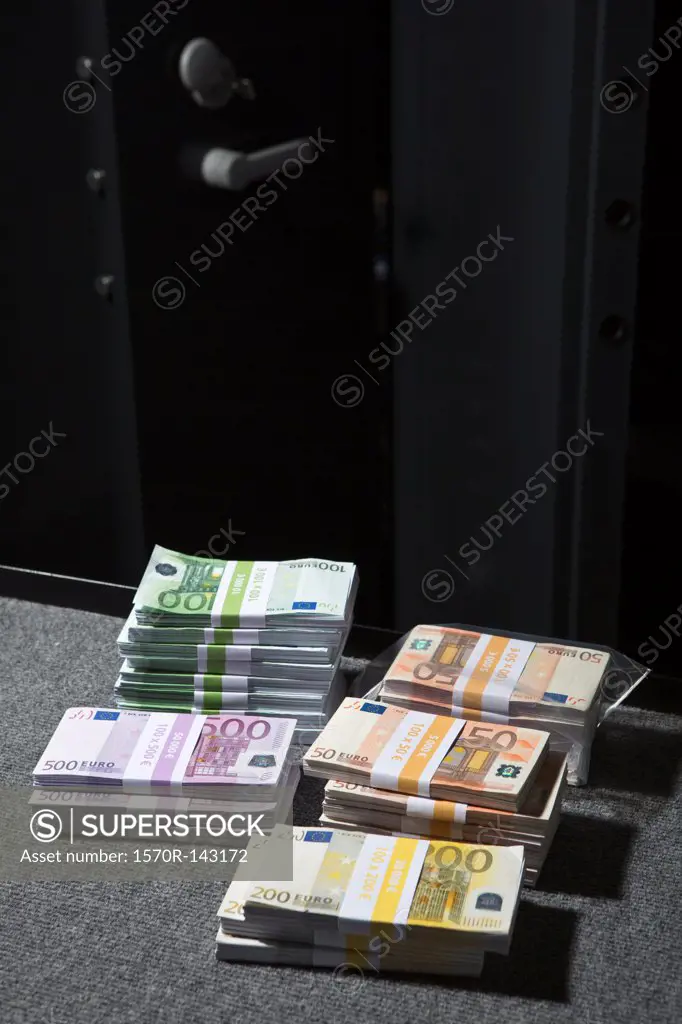 Stacks of large billed Euro banknotes on a table outside of a vault
