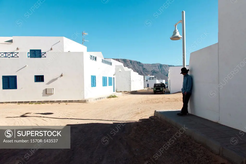 Man leaning against wall in Caleta Del Sebo, Canary Islands, Spain