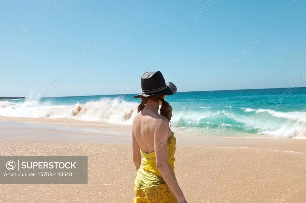 Woman on beach looking at waves