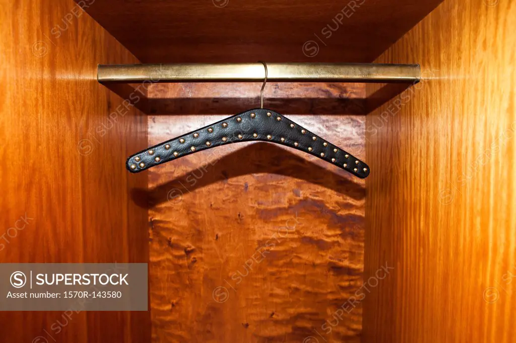 Studded leather belt hanger in wardrobe