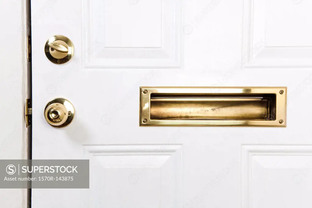 A front door with mail slot, doorknob and deadbolt lock