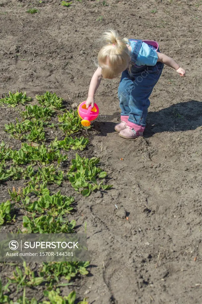 Girl watering plants with her watering can
