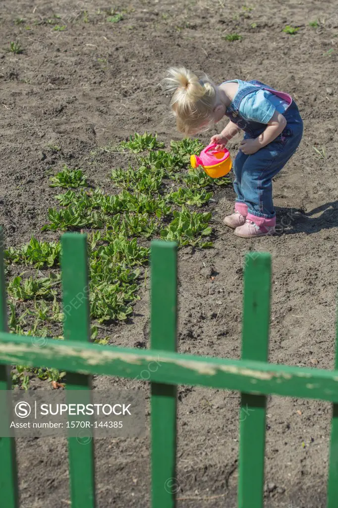 Girl watering plants with her watering can