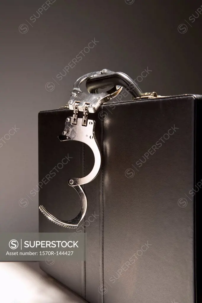 A briefcase with handcuffs attached to the handle