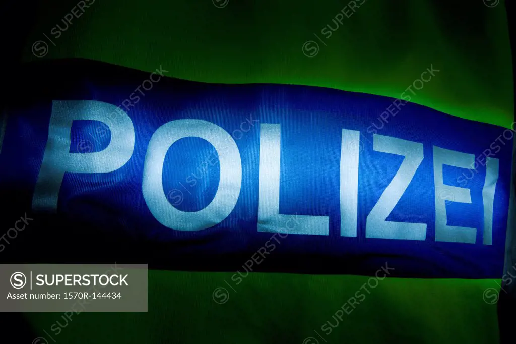 Polizei (Police in German) written on the back of a reflection jacket, back lit
