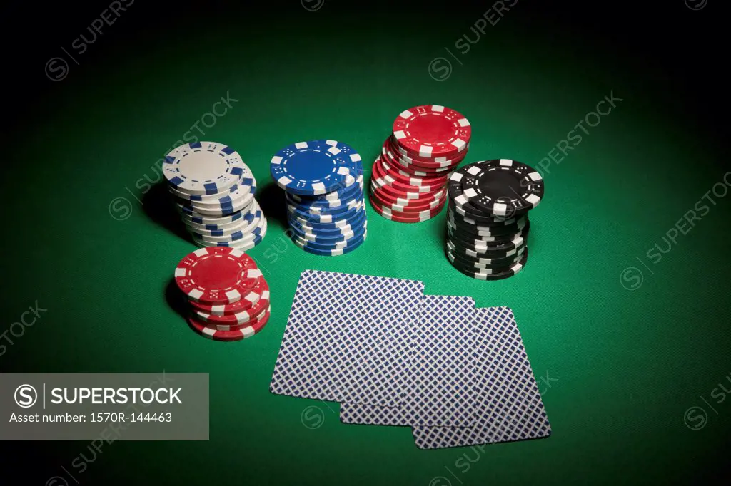 A hand of cards facedown, surrounded by stacks of gambling chips
