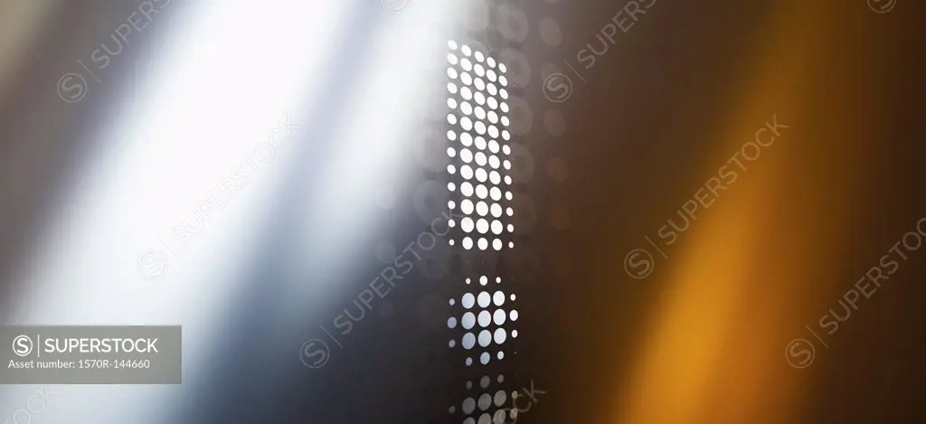 Spotted exclamation mark against a background of colored light and shadow