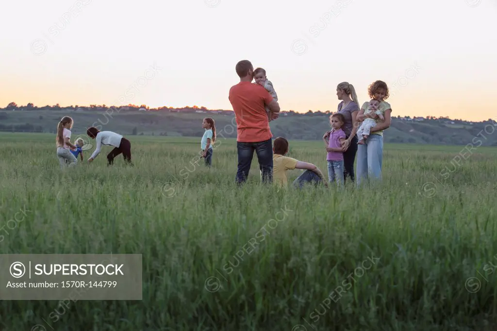 Families relaxing in a field in a rural setting