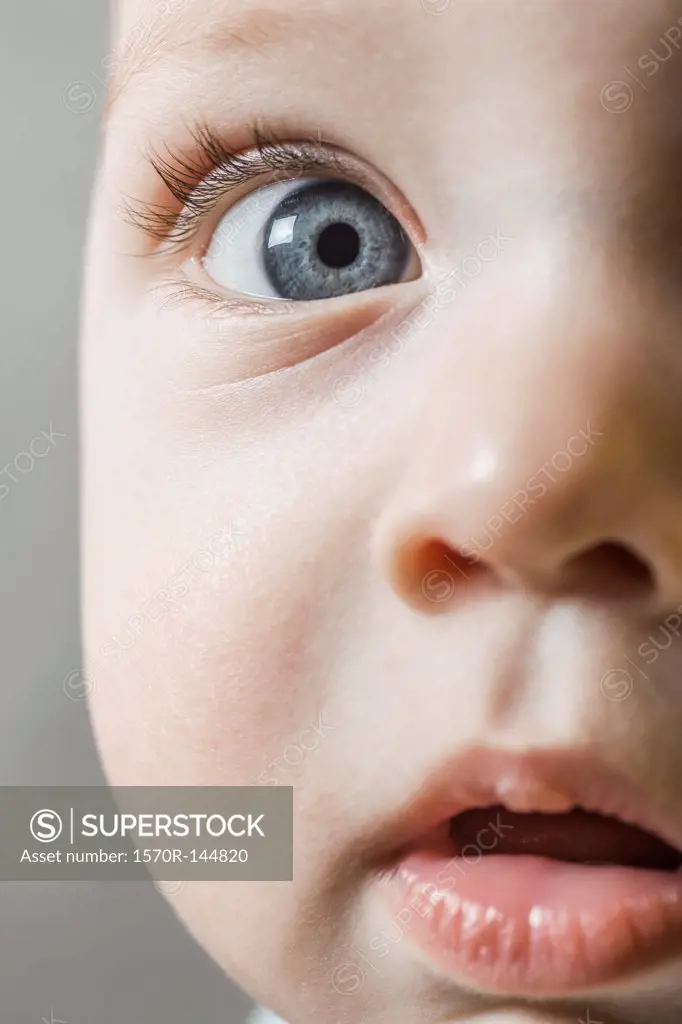 A baby boy looking curiously into the camera, extreme close-up