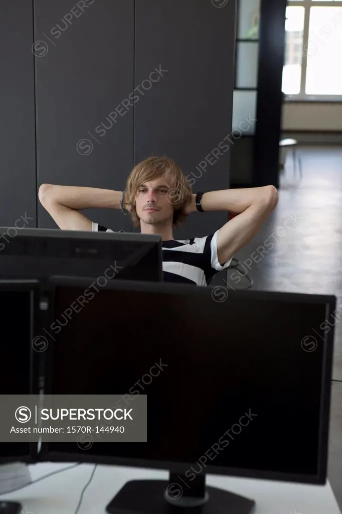 Man relaxing at computer desk