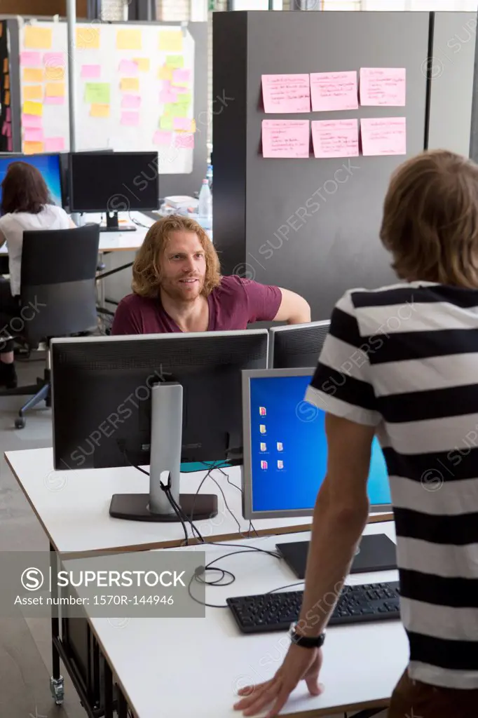 Colleagues talking with each other in office