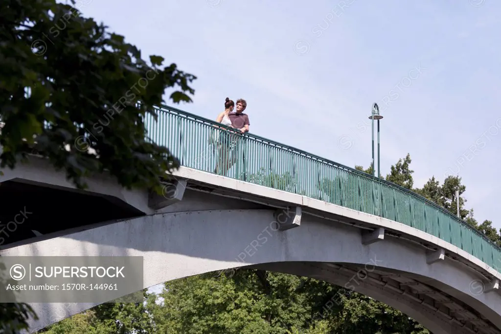 Young couple standing on bridge