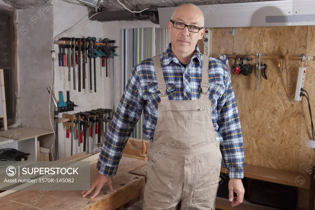 Mature man standing in carpenter shop, portrait