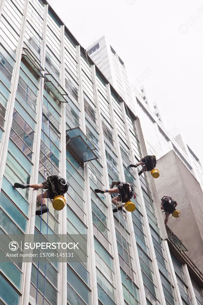 Workers cleaning the glass windows of skyscraper