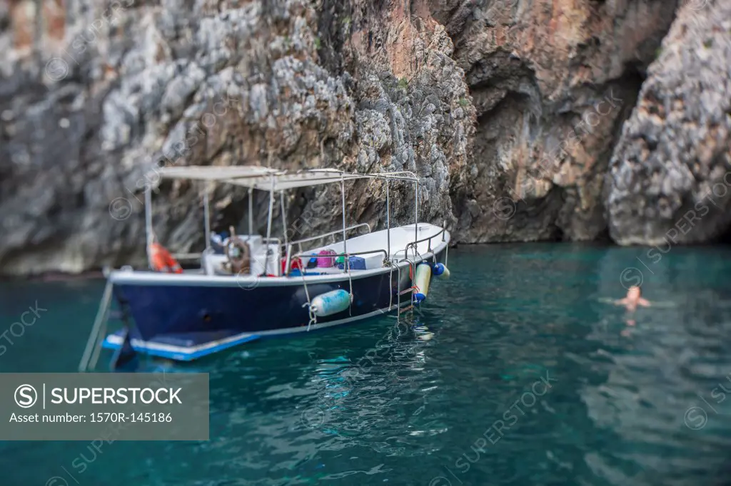 Boat floating on water by rock formation