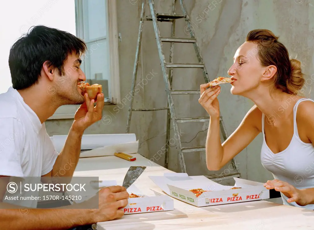 A couple eating pizza