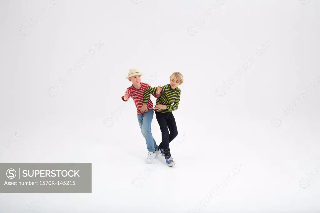 Two boys fighting against white background