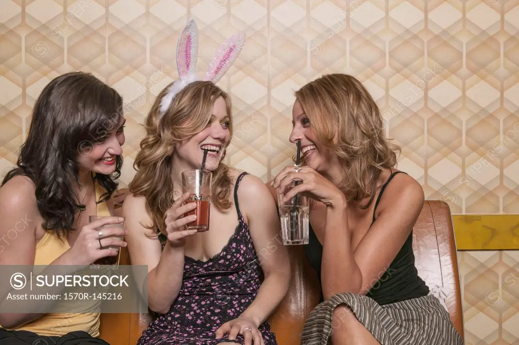Three women drinking cocktails together