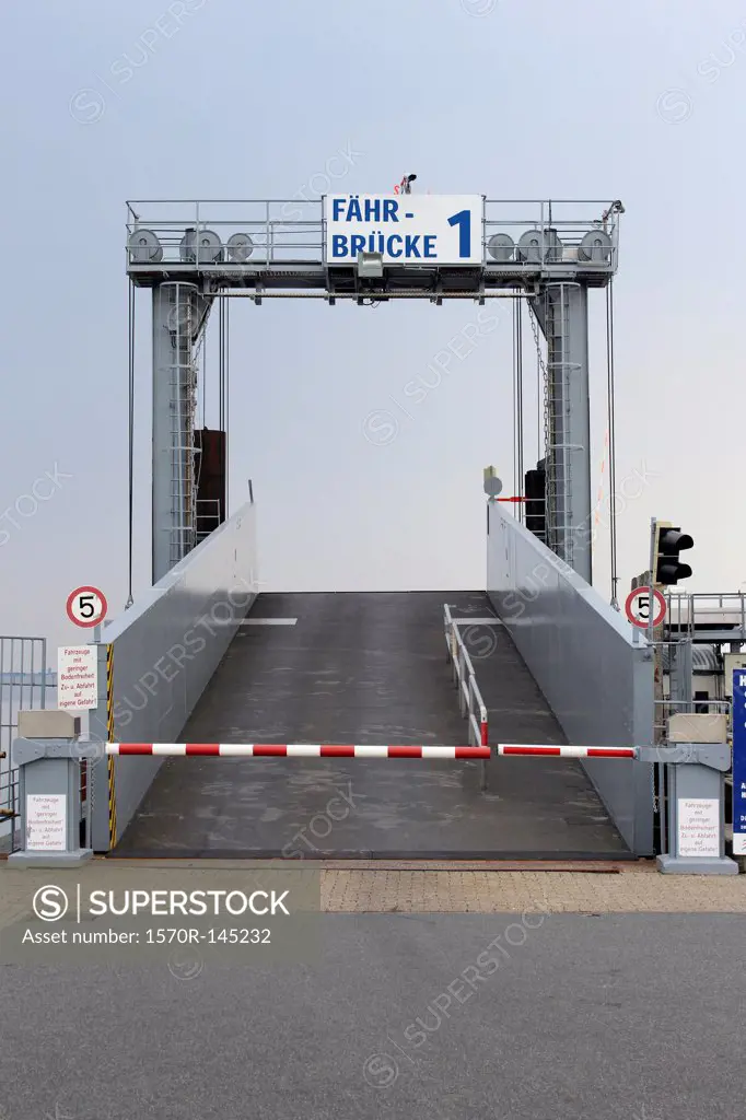 A bridge used to load cars onto a ferry, with German language sign