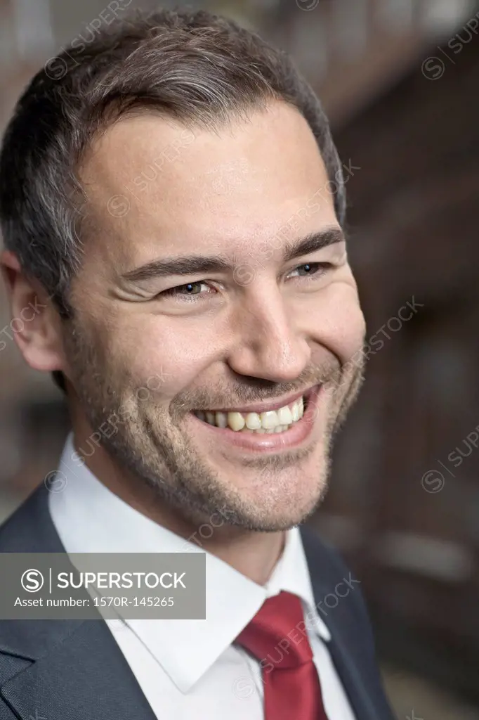 Mid adult man looking away and smiling, close-up
