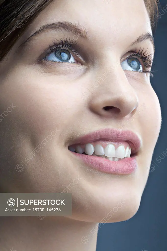 Young woman looking up and smiling, close-up