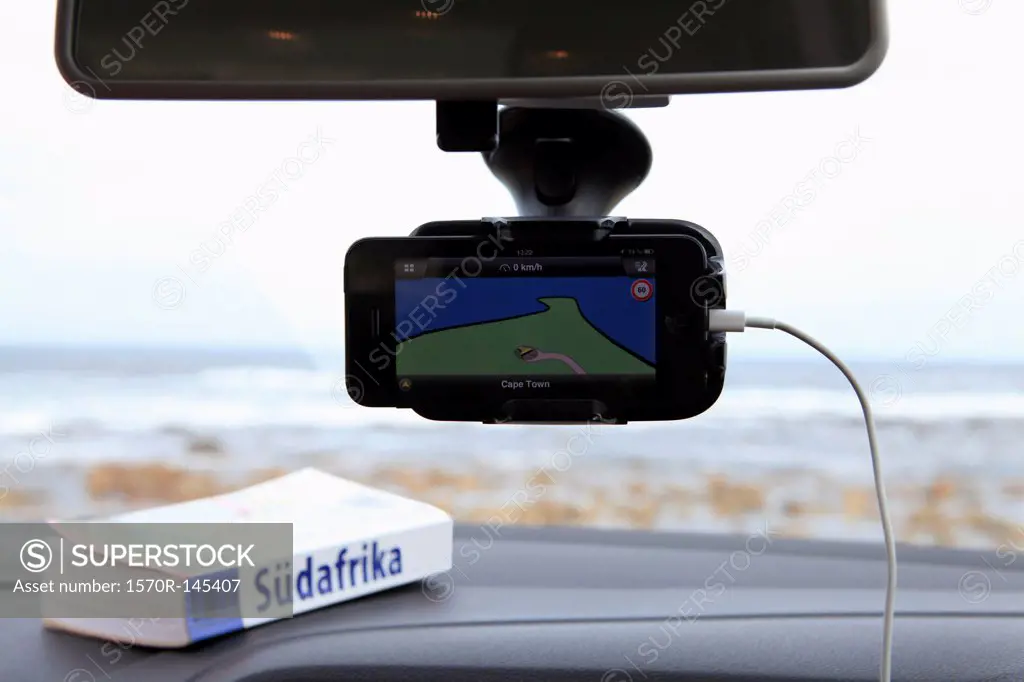 A GPS and South African guidebook on car dashboard