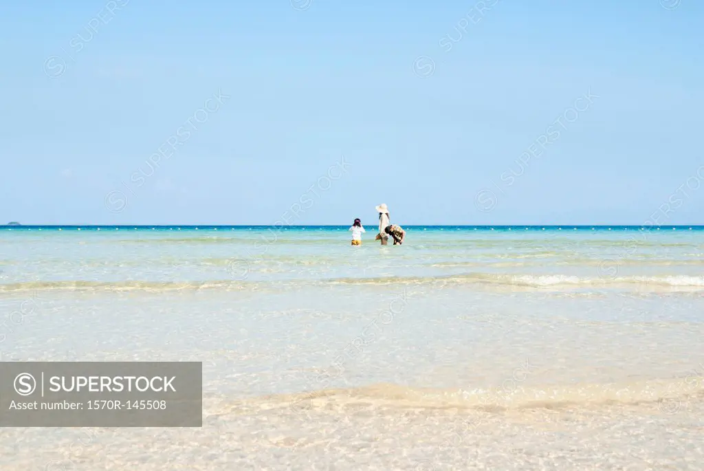Mother with daughter and son enjoying at beach, distant