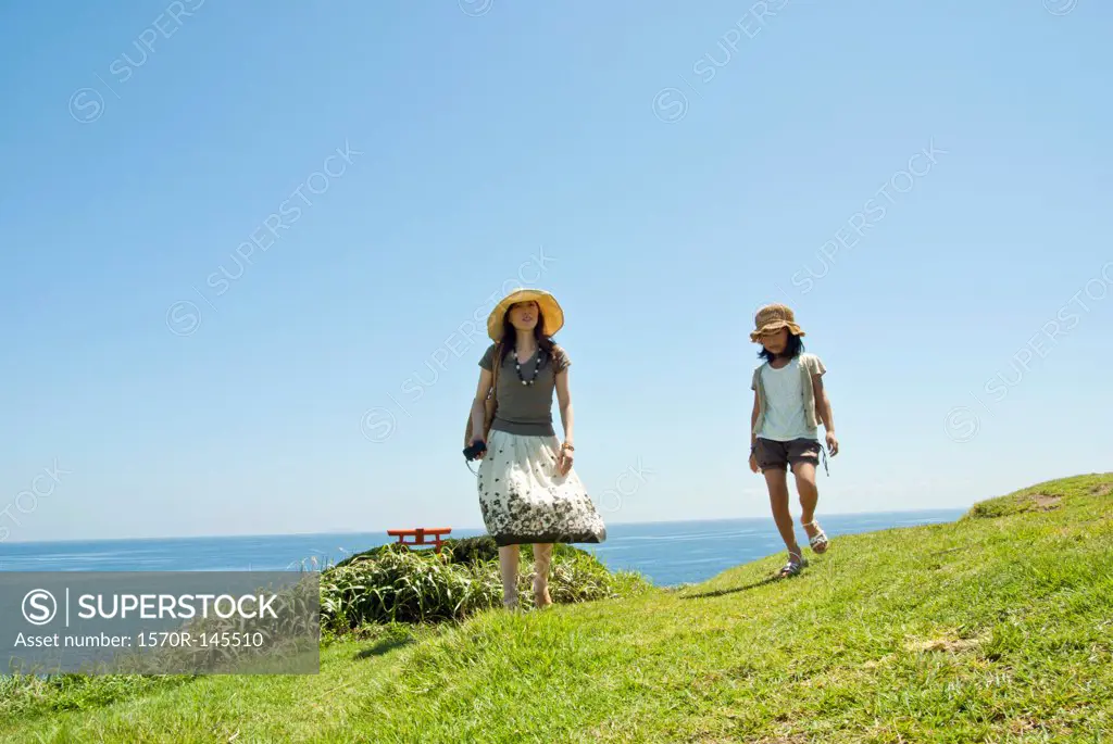 Mother walking with daughter at coastline