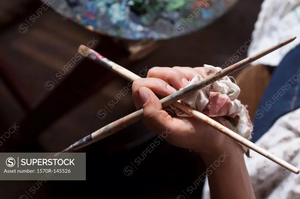 Human hand holding paintbrush, close-up
