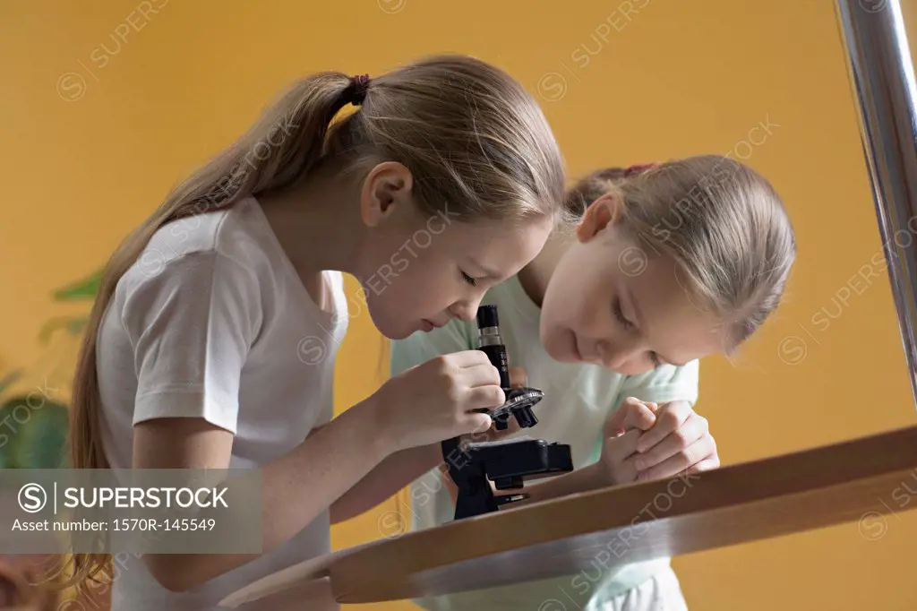 Girls looking through microscope