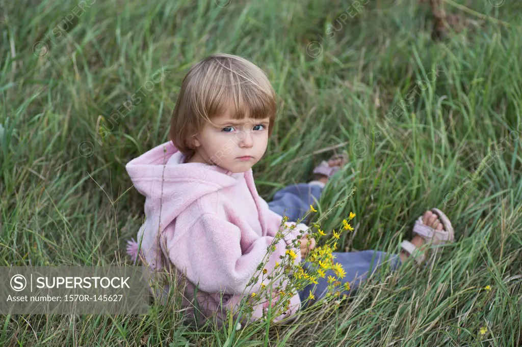 Girl sitting on grass, portrait