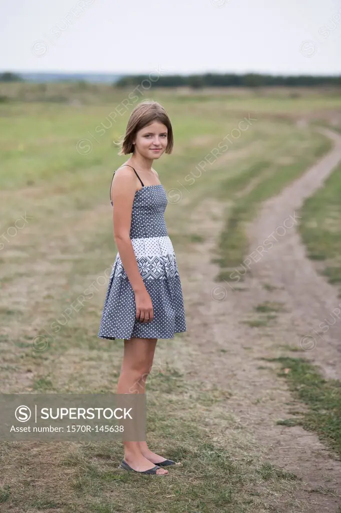 Portrait of teenage girl standing near dirt track