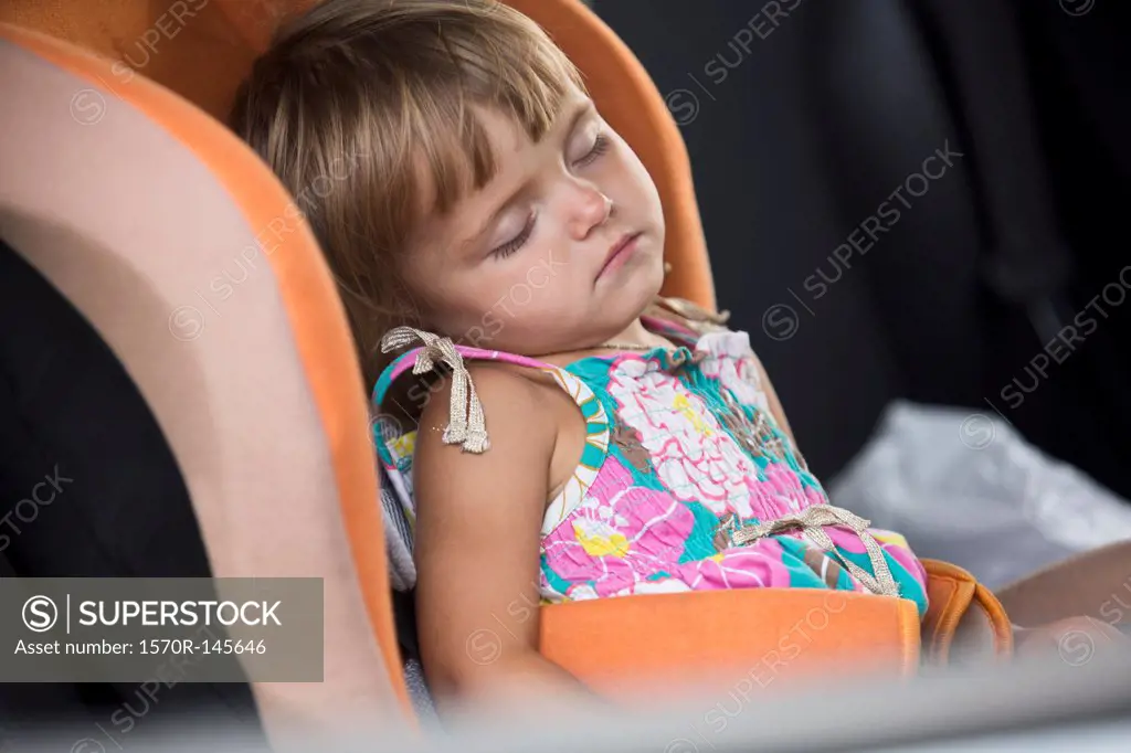 Baby girl sleeping on vehicle seat