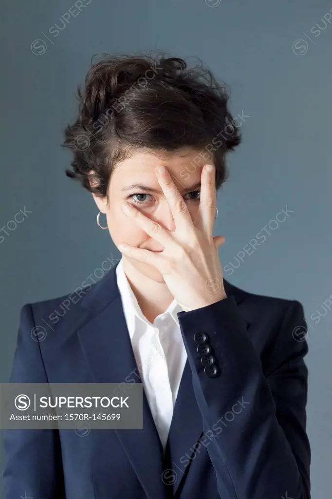 Mid adult woman covering her eyes in embarrassment