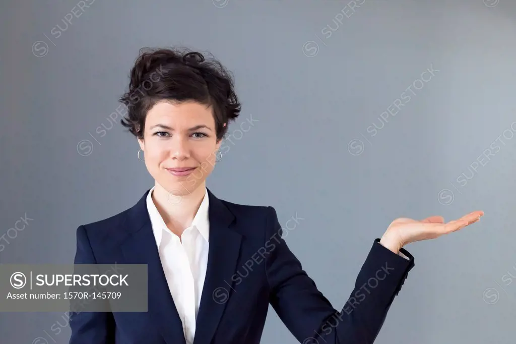 A smiling mid adult woman with her palm out in anticipation