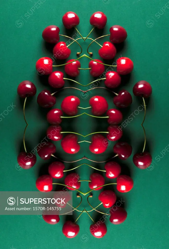 A digital composite of mirrored images of an arrangement of cherries