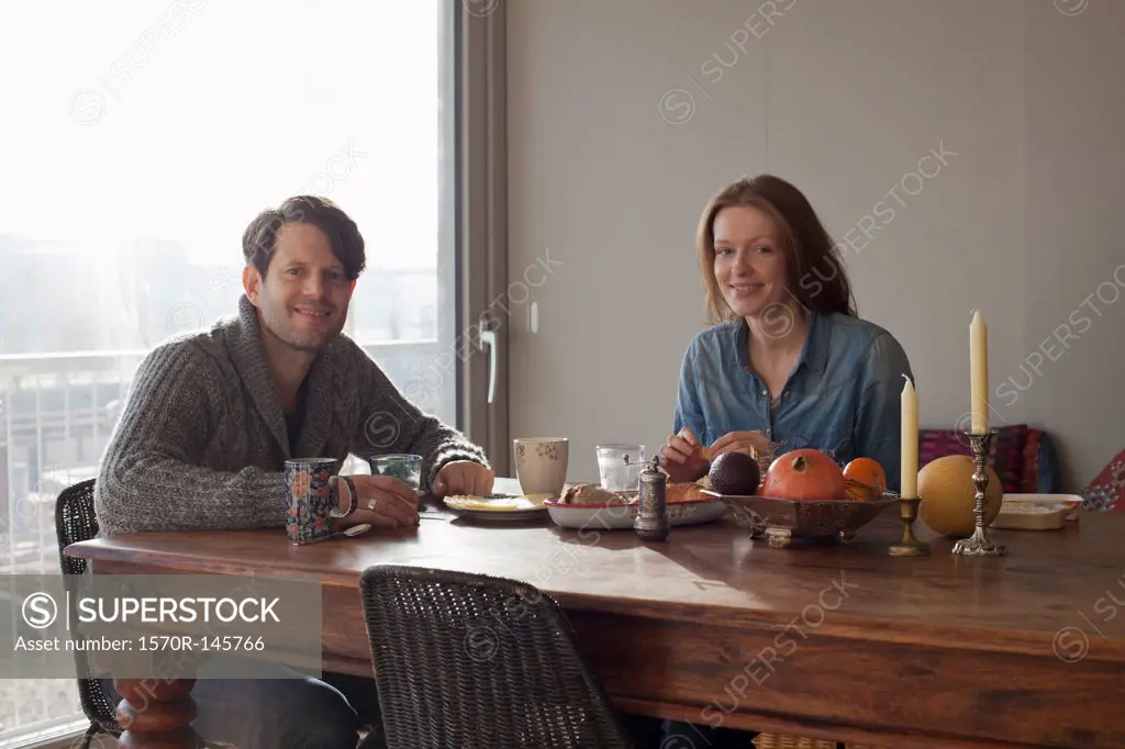 Couple having breakfast at dining table, portrait