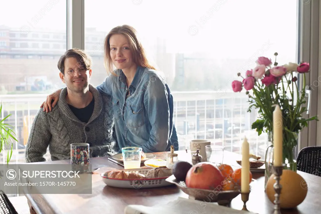 Couple sitting at dining table with breakfast
