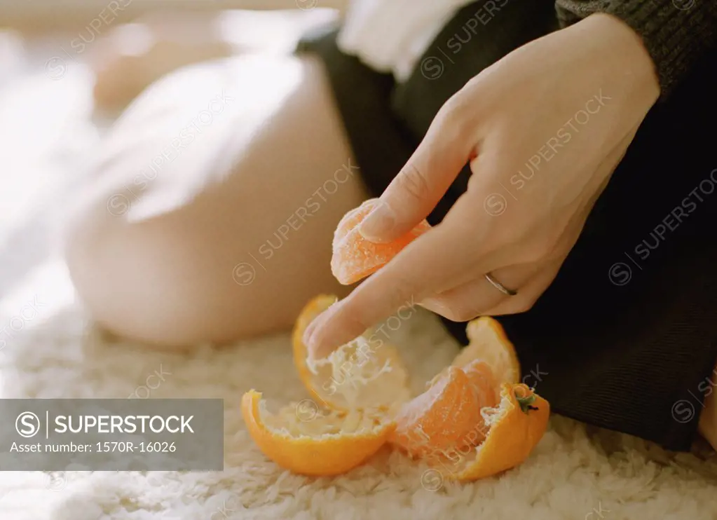 woman's hand holding peeled tangerine