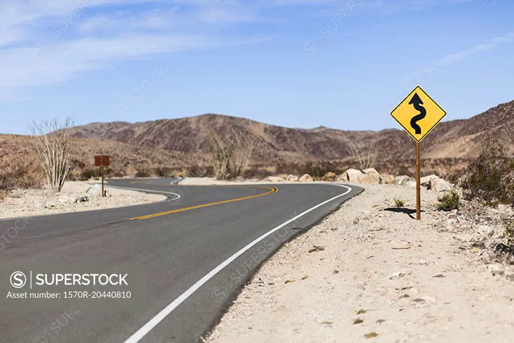 Directional sign by road at Joshua Tree National Park against sky